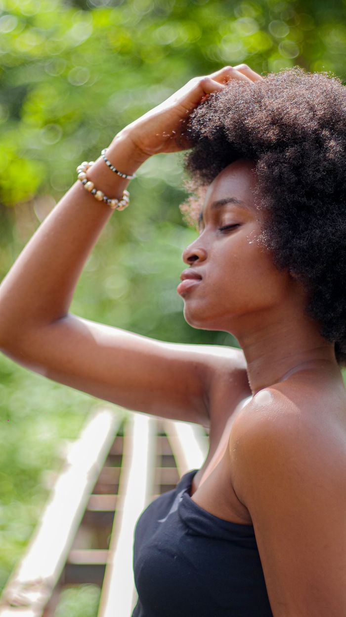 Elegant profile of a young woman with natural hair in an outdoor setting in Dakar.